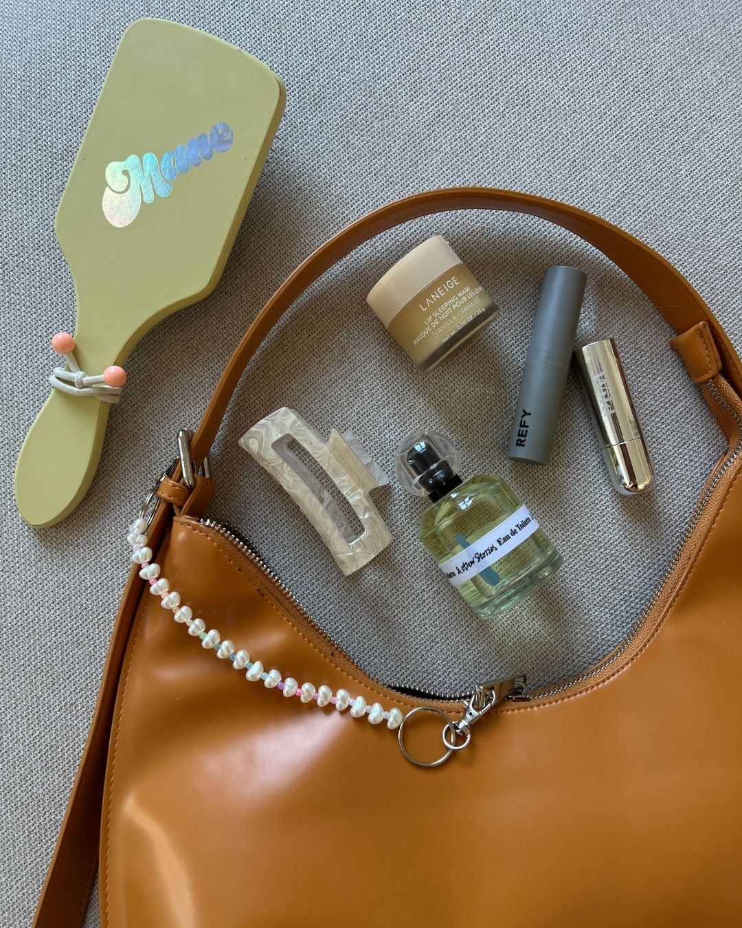 Rainbow bag charm on the orange bag - flatlay
